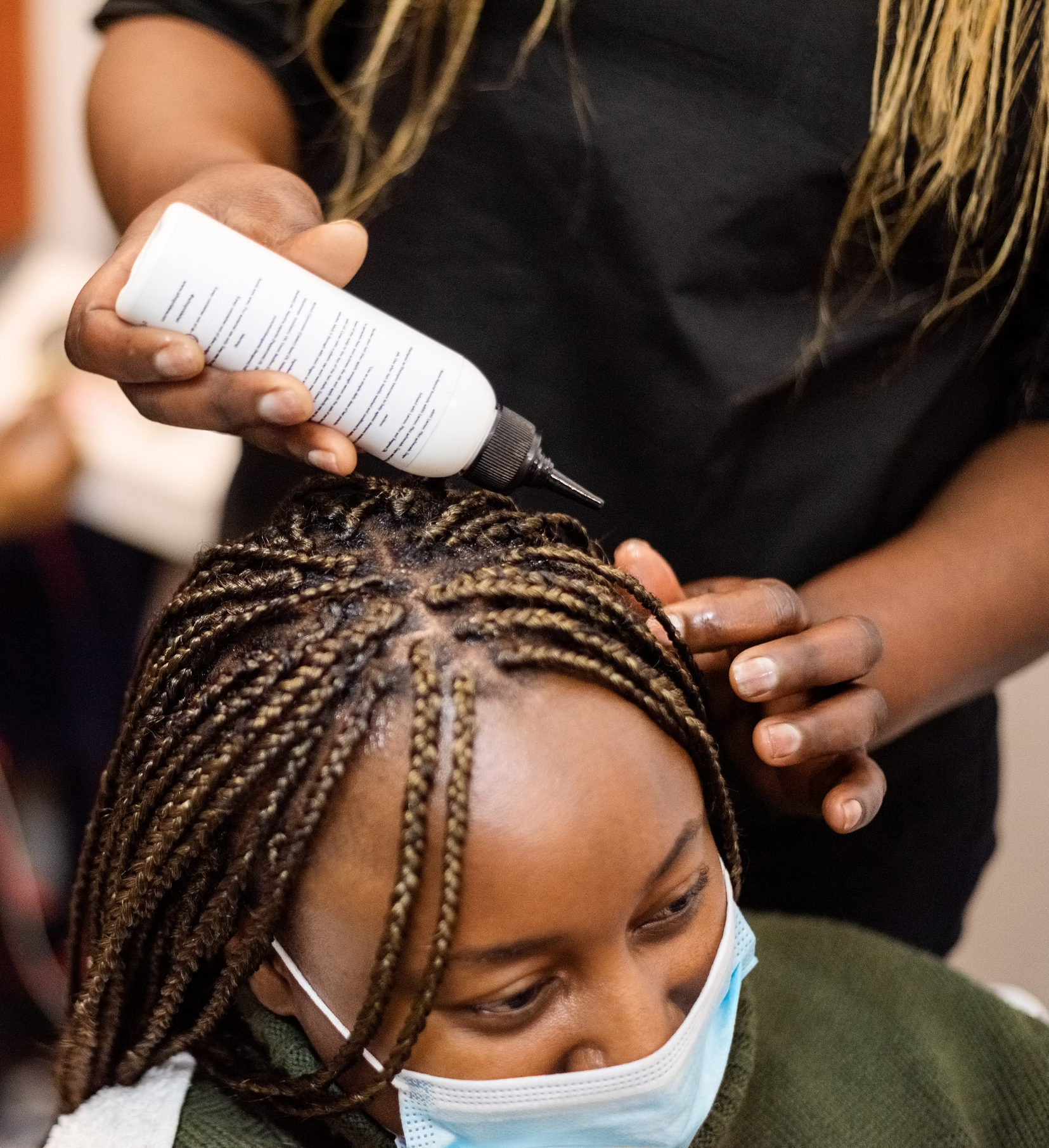 Woman in beauty salon getting her braided hair moisturised