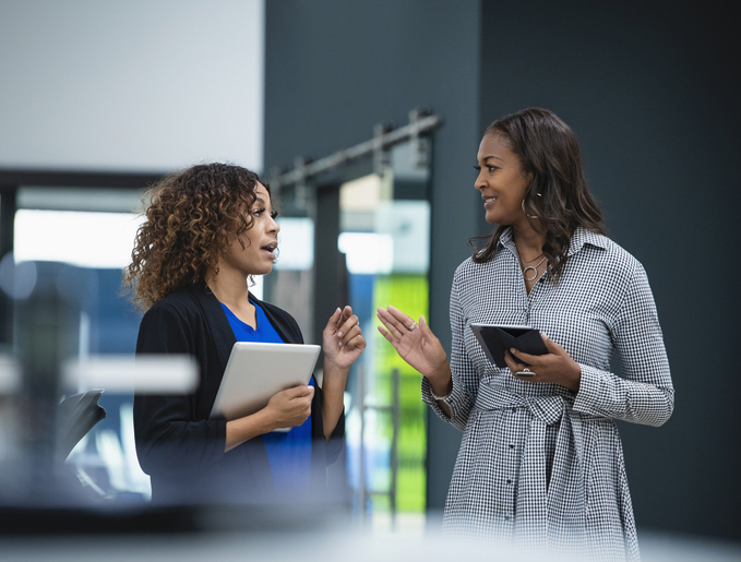 Two business women talking in office