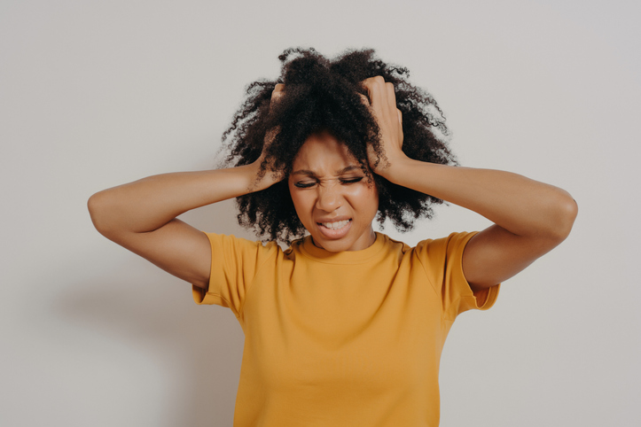 Beautiful african young woman standing in casual clothes angry and mad, screaming in anger