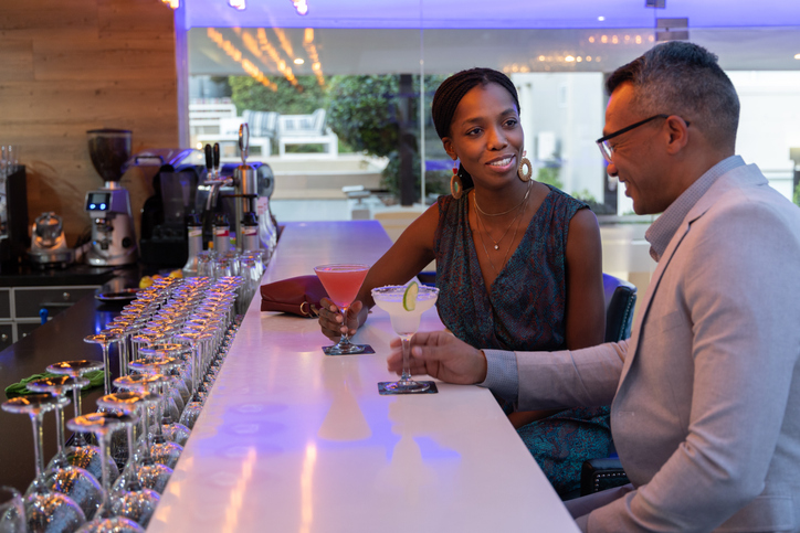 Couple drinking cocktails together in hotel bar
