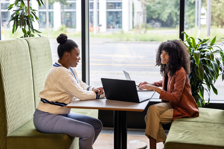Two businesswomen discussing work sitting at a restaurant