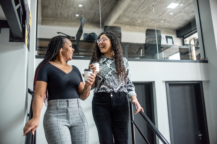 Two businesswomen walking down the coworking stairs