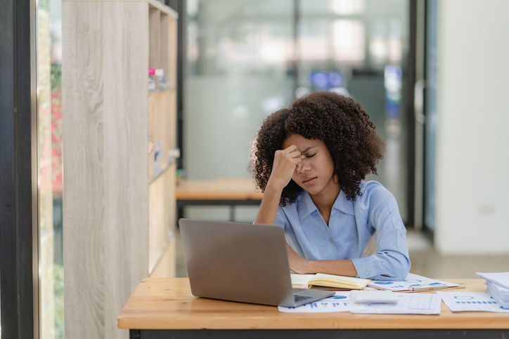 Frustrated business woman with stress dealing with productivity killers