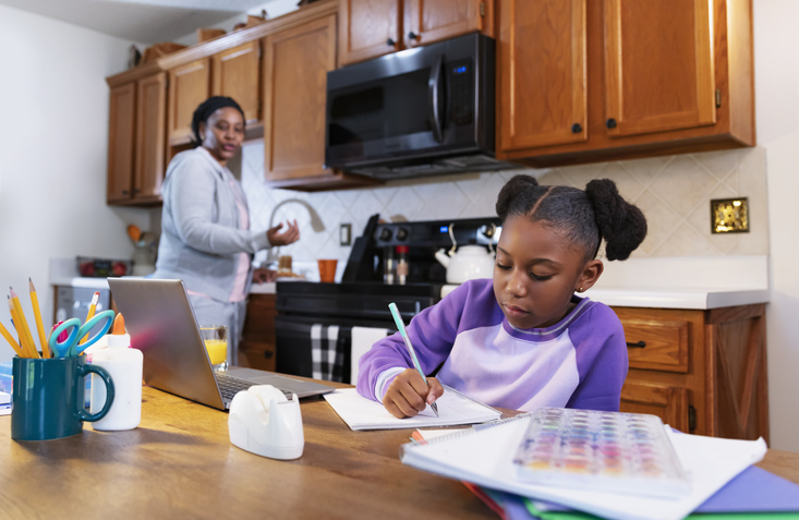 African-American girl studying, grandmother watching