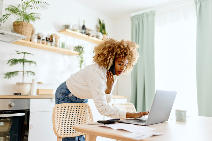 Beautiful woman typing on a laptop buying a house