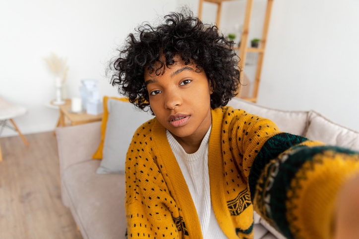 Happy african american teen girl blogger smiling face talking to webcam recording vlog. Social media influencer woman streaming making video call at home. Headshot portrait selfie webcamera view.