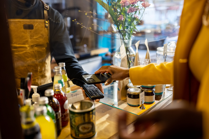 Woman paying through phone at a small cafe