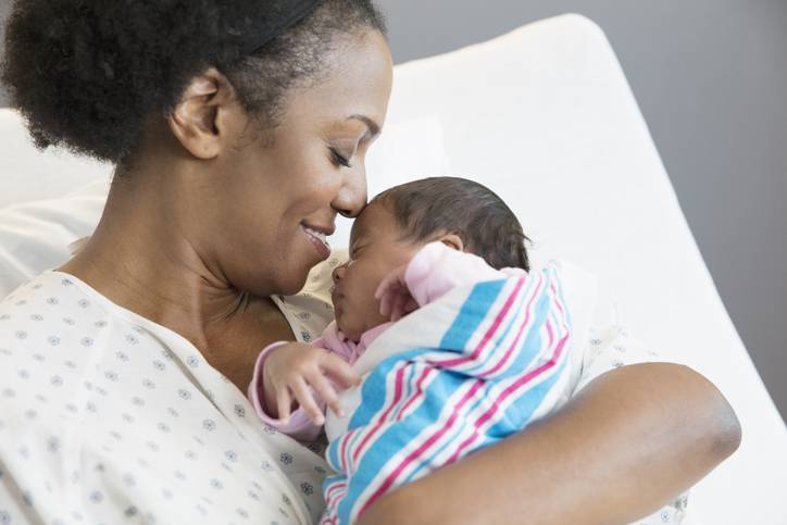 Mother with newborn at hospital room after receiving support from a doula and midwife