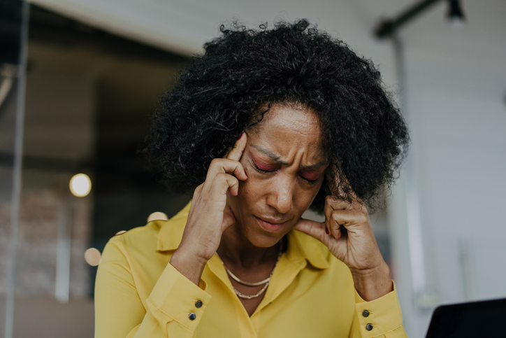 Business woman with headache due to menopause