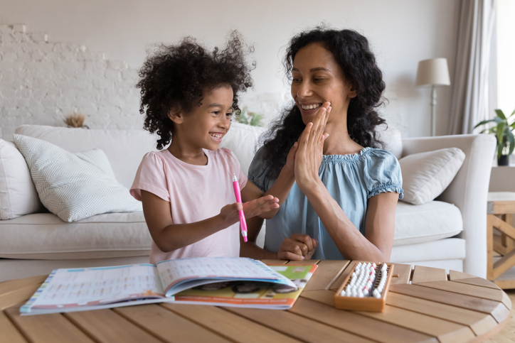 Excited mom and cheerful kid girl clapping high five hands