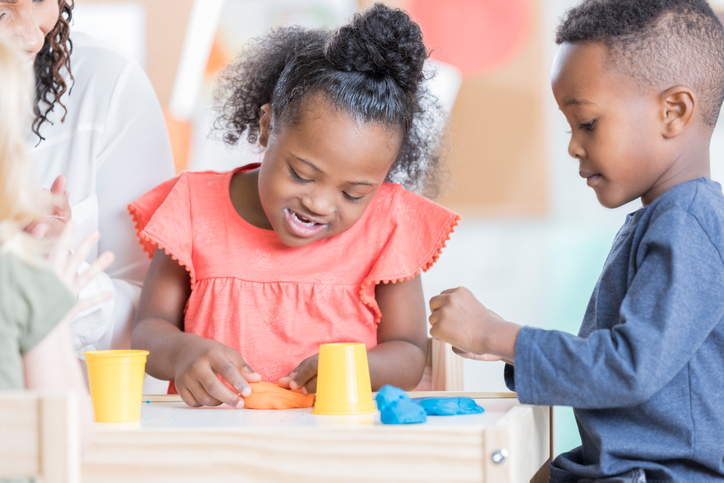 Little girl with special needs plays with friend