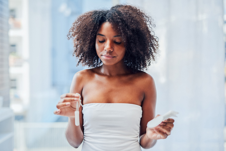 woman dealing with period poverty menstruation buying pads and tampons