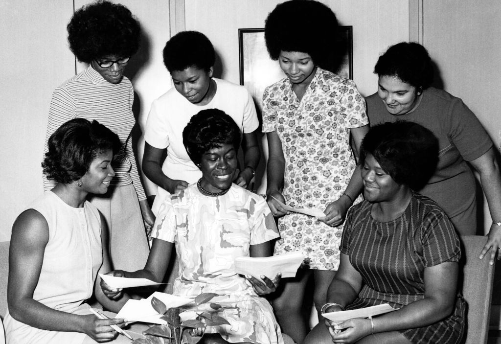 Woman distributing papers with students