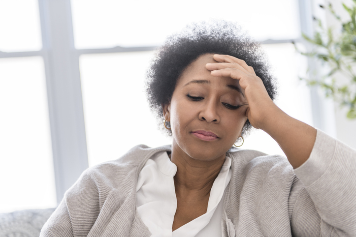 Black woman sitting on sofa at home have bad time