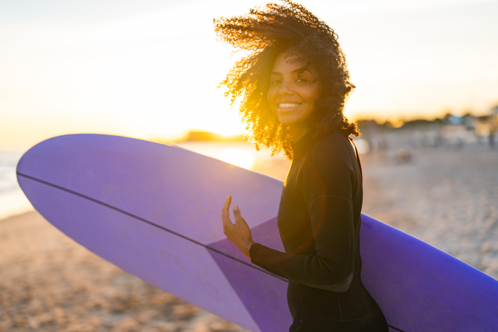 Joyful Black Female Surfer with Board on Beach