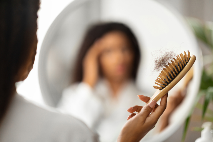 Hairloss. Upset Black Woman Holding Comb Full Of Fallen Hair After Brushing