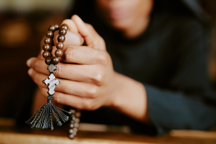 Unrecognizable Young Nun Holding Rosary