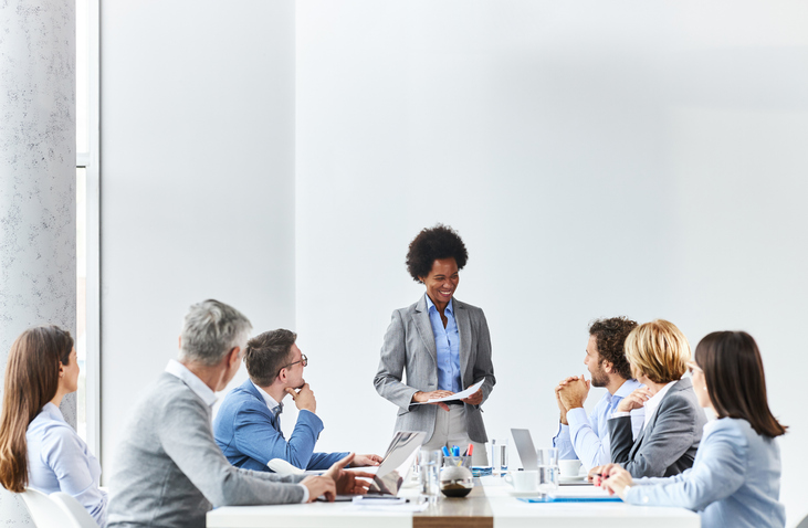 Black CEO giving a speech to her colleagues in the office.