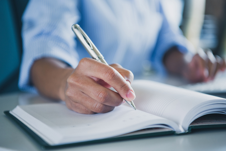 Cropped photo of lady assistant arm hand wear shirt writing copybook indoors workplace workstation