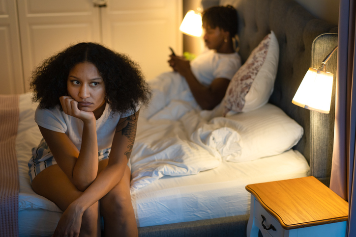 Depressed woman after a fight with her boyfriend in bedroom