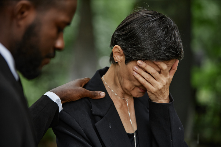 Senior Woman Covering Face with Hand Grieving Loss at Gravesite