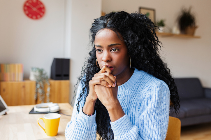 Pensive thoughtful Hispanic Latin woman with distressed mood thinking and planning.