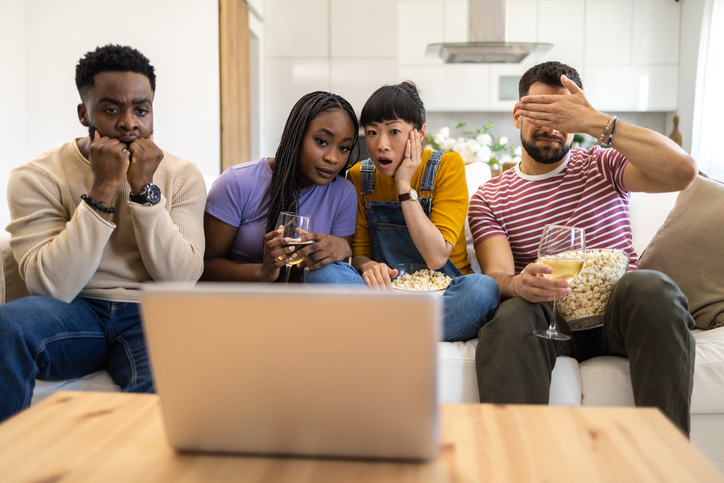Diverse group of friends watching movie online on the laptop