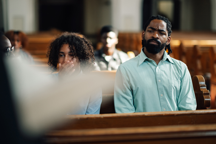 Congregation members sitting in church pew listening to sermon