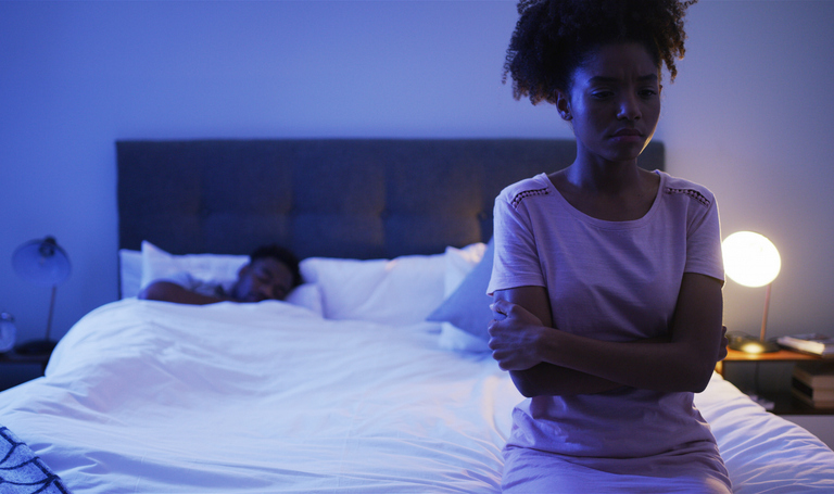 Depressed, woman and bed with African couple, night and marriage trouble from infertility with stress and fight. Bedroom, sit and thinking of divorce and relationship conflict at home with insomnia