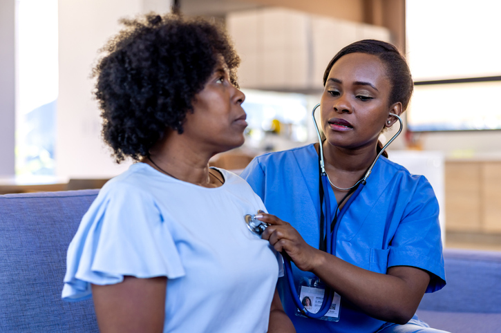 Doctor making a house call examining a senior woman