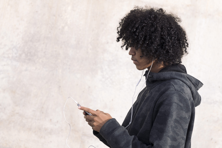 teenage boy listening music with earphones