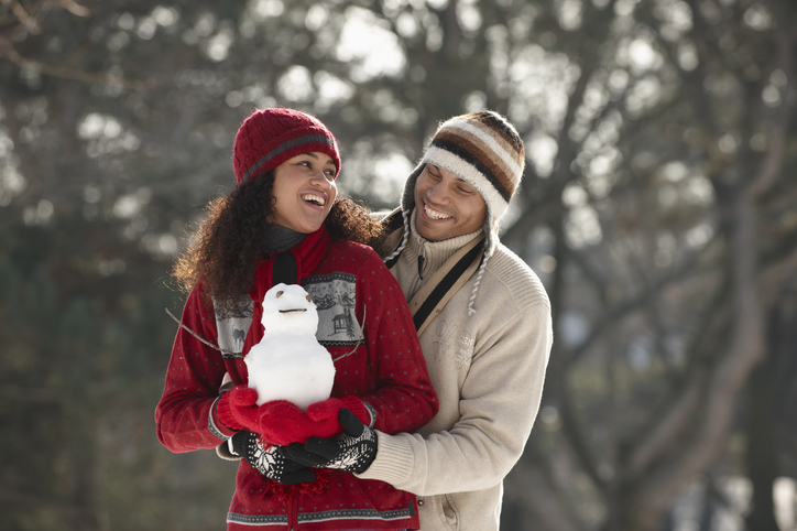 Couple making small snowman