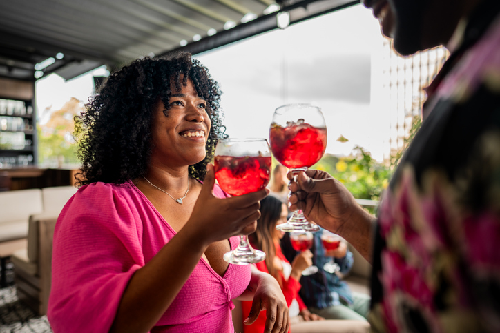 Mid adult woman toasting with boyfriend in the restaurant at rooftoop