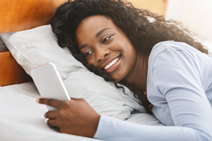 Close up of smiling girl reading messages on smartphone