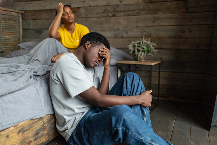 Young adult couple with relationship difficulties in bedroom