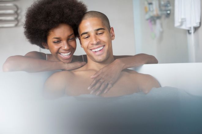 Woman hugging boyfriend in bath