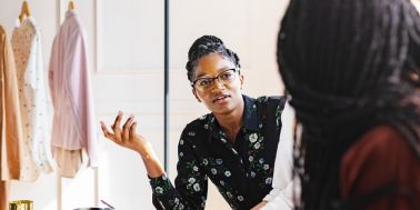 African American woman in glasses, in conversation.