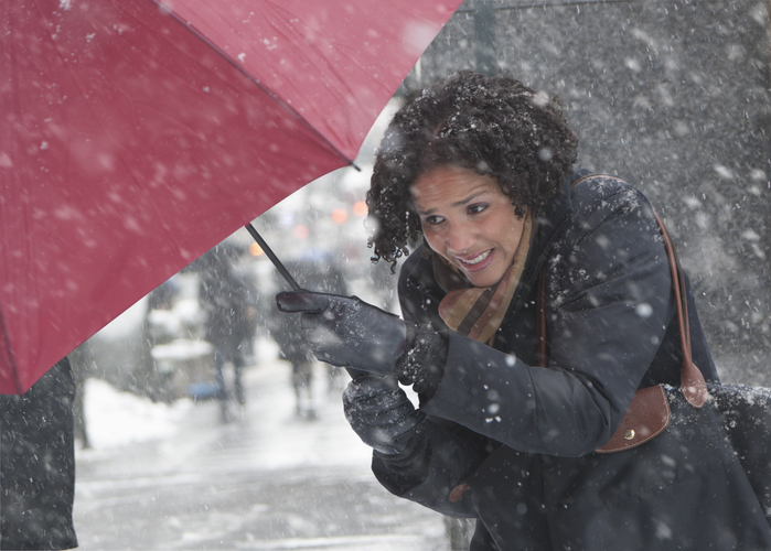 Young woman walking in a snow storm