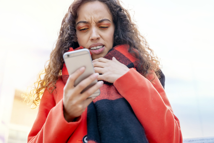 Outdoor portrait of an upset woman using a mobile phone visiting a Europe city