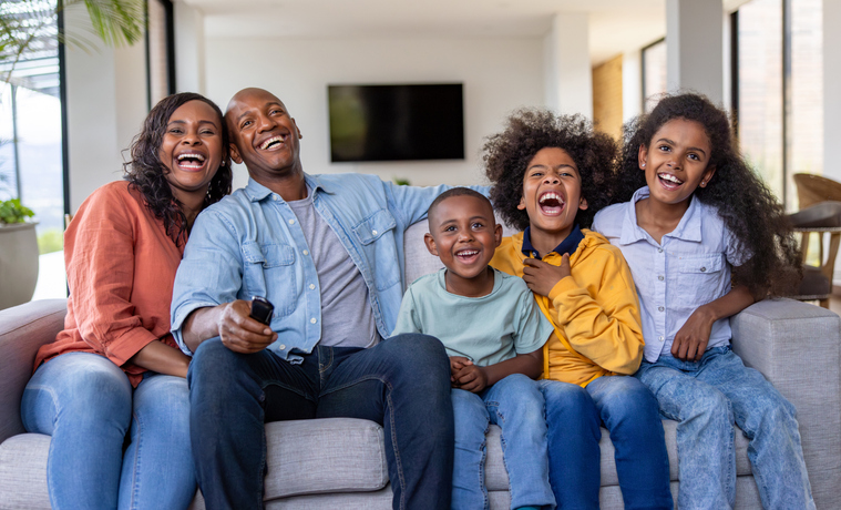 Happy family having fun watching tv together at home