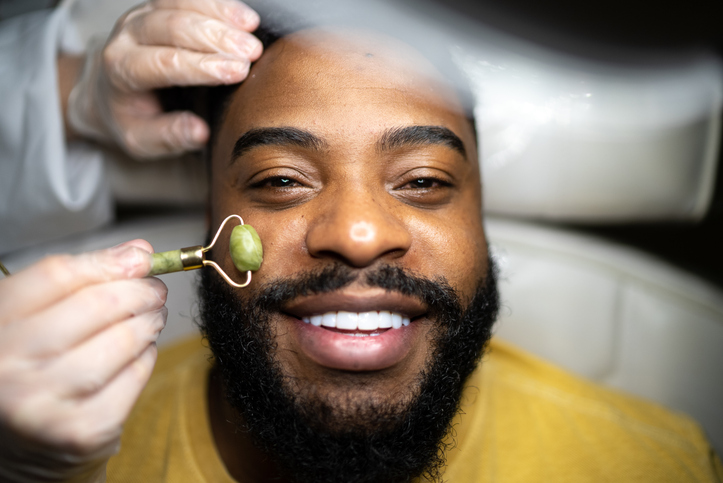 Portrait of a mid adult man receiving a facial massage at a spa