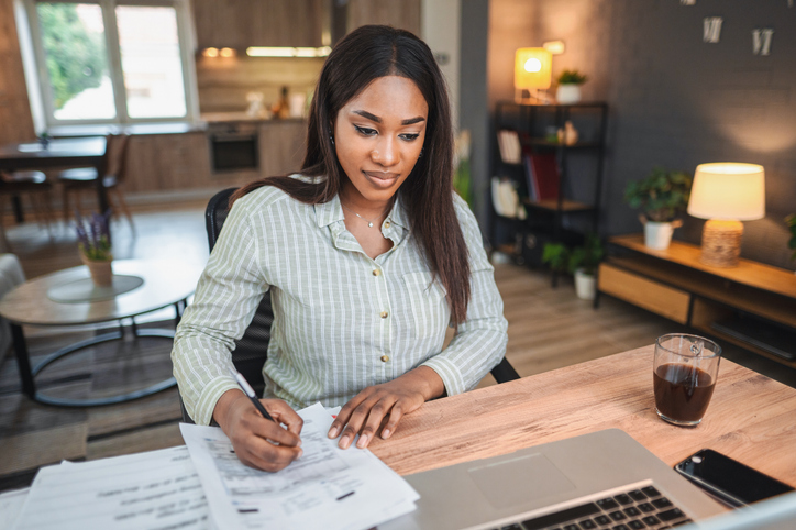 Focused young woman managing invoices and bills at home office