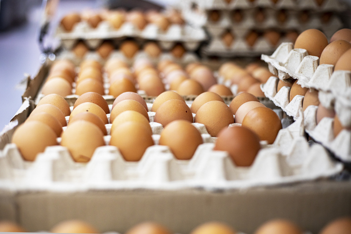 chicken brown eggs in large cardboard containers stacked on top of each other on a counter in a supermarket. Farm. preparing for Easter - Eggs, flaxseed, price, alternative, aquafaba, tofu, bananas
