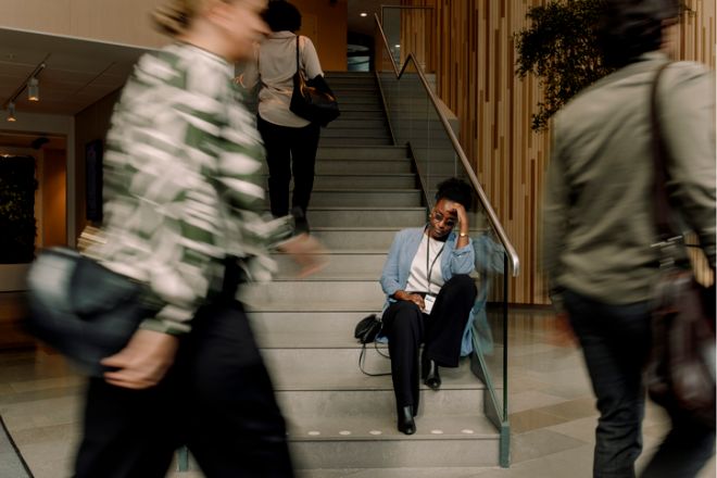 Stressed businesswoman sitting on steps at convention center