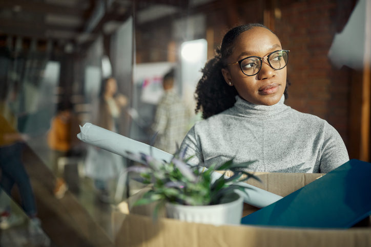 Worried black woman leaving the office after quitting a job.