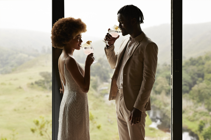 Young just married couple drinking by window