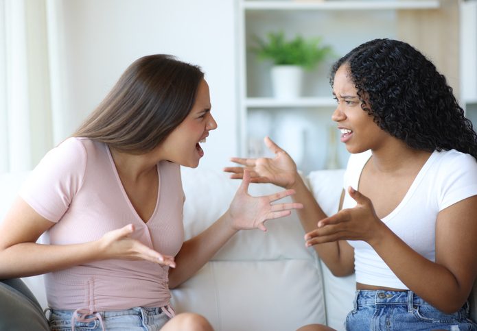Angry interracial friends arguing at home