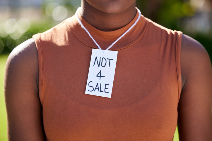 Shot of a unrecognizable woman wearing a sing on her neck in protest outside