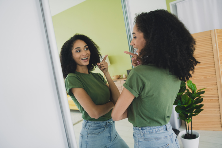 Portrait of nice young woman point finger reflection mirror wear t-shirt free time modern interior flat indoors