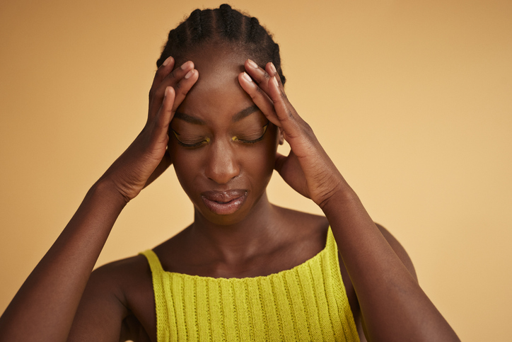 Tensed young woman with head in hands